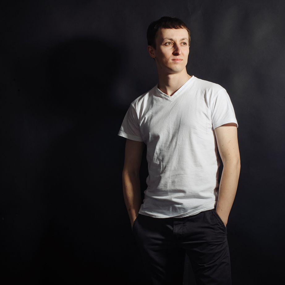 Beautiful young man in white shirt on a black background